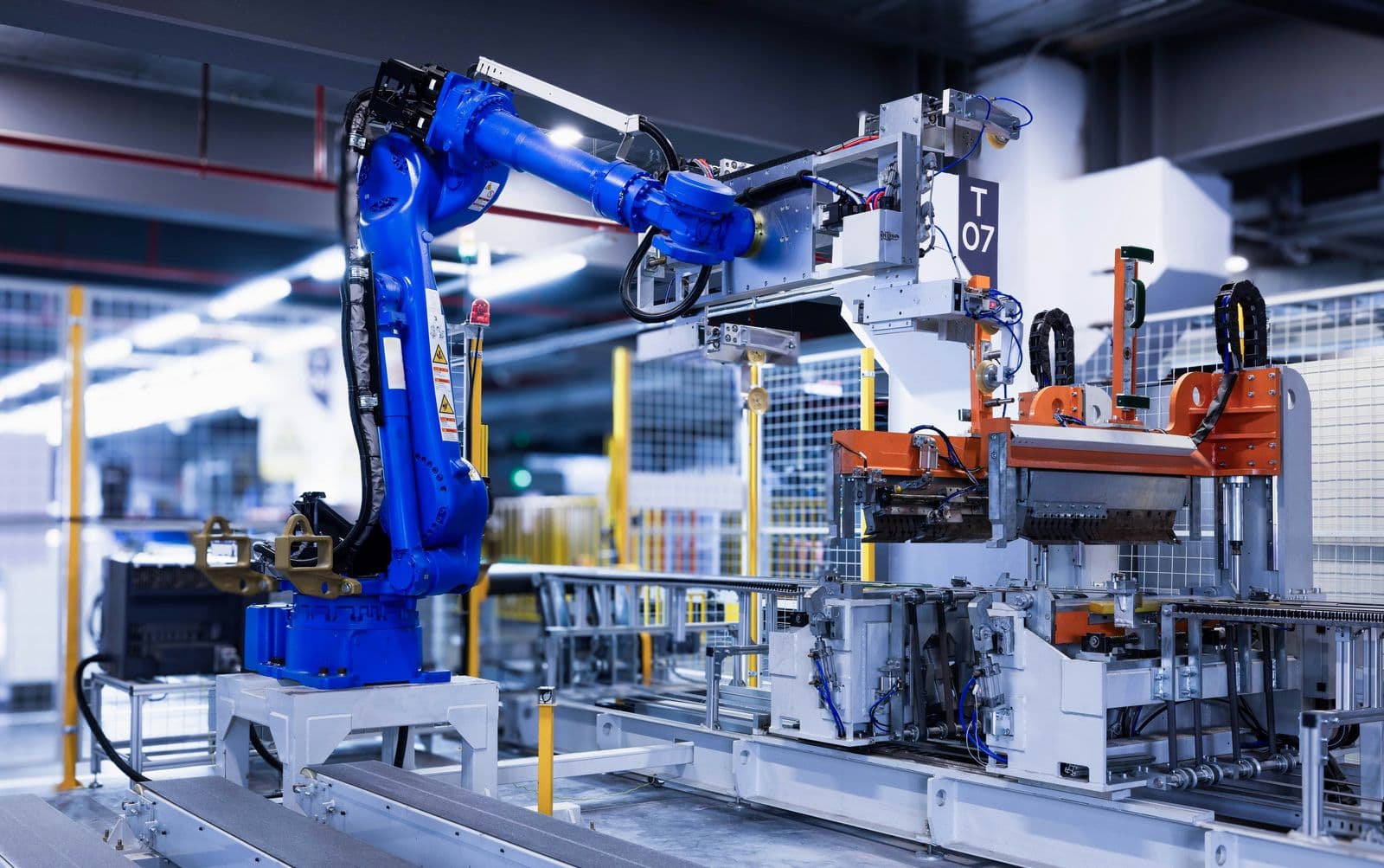 Blue industrial robot arm running an automated task on a factory line